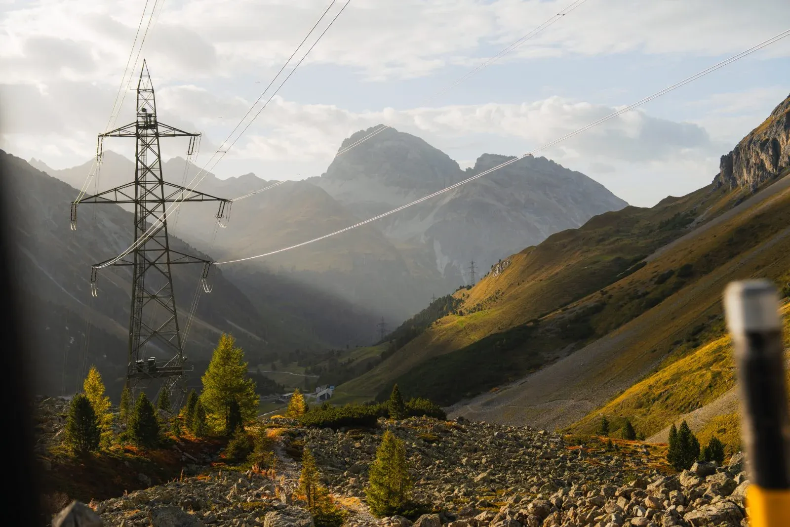 Electricity transmission tower and power lines running through a mountain valley