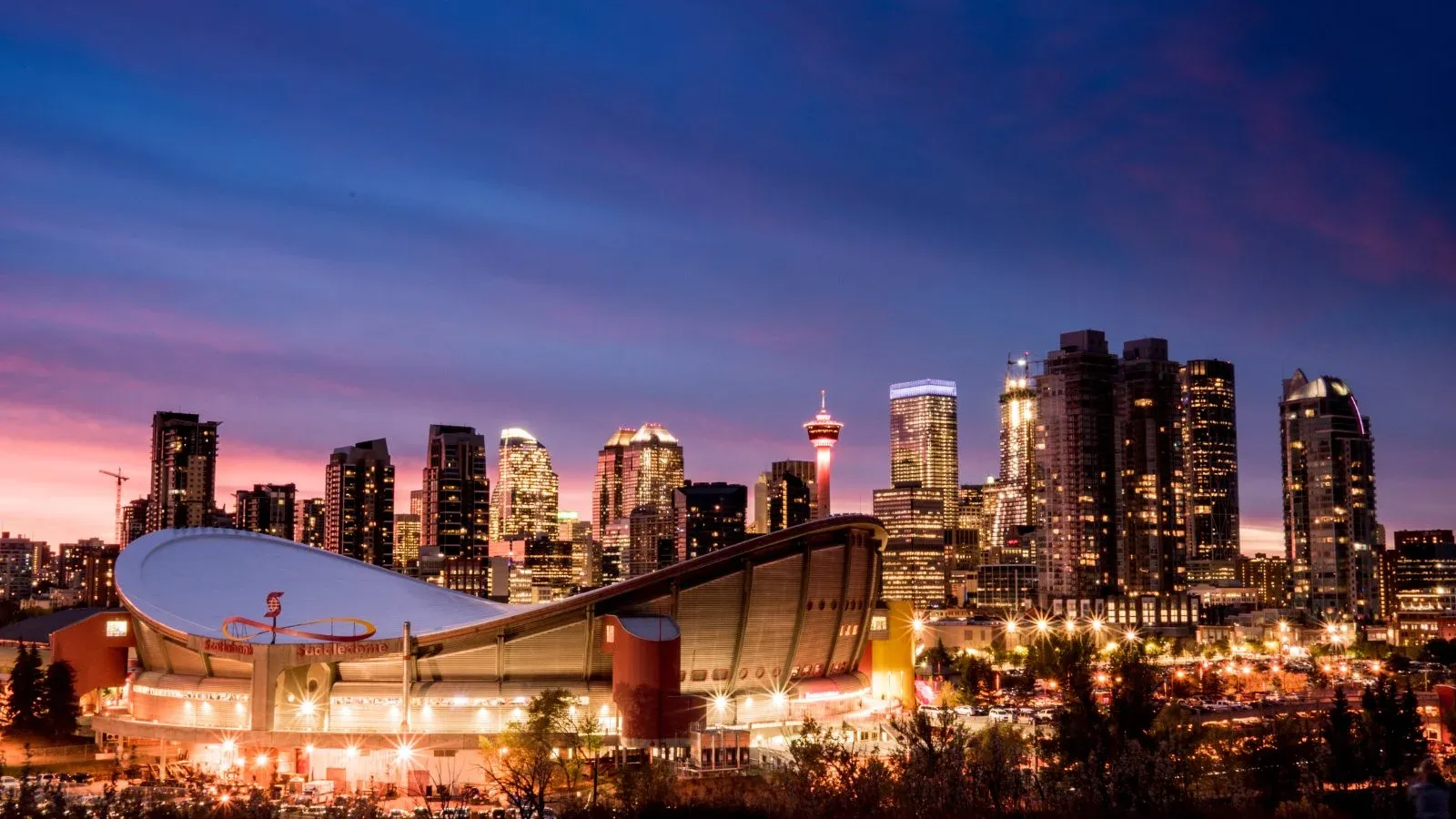 Calgary skyline and arena lit up at dusk